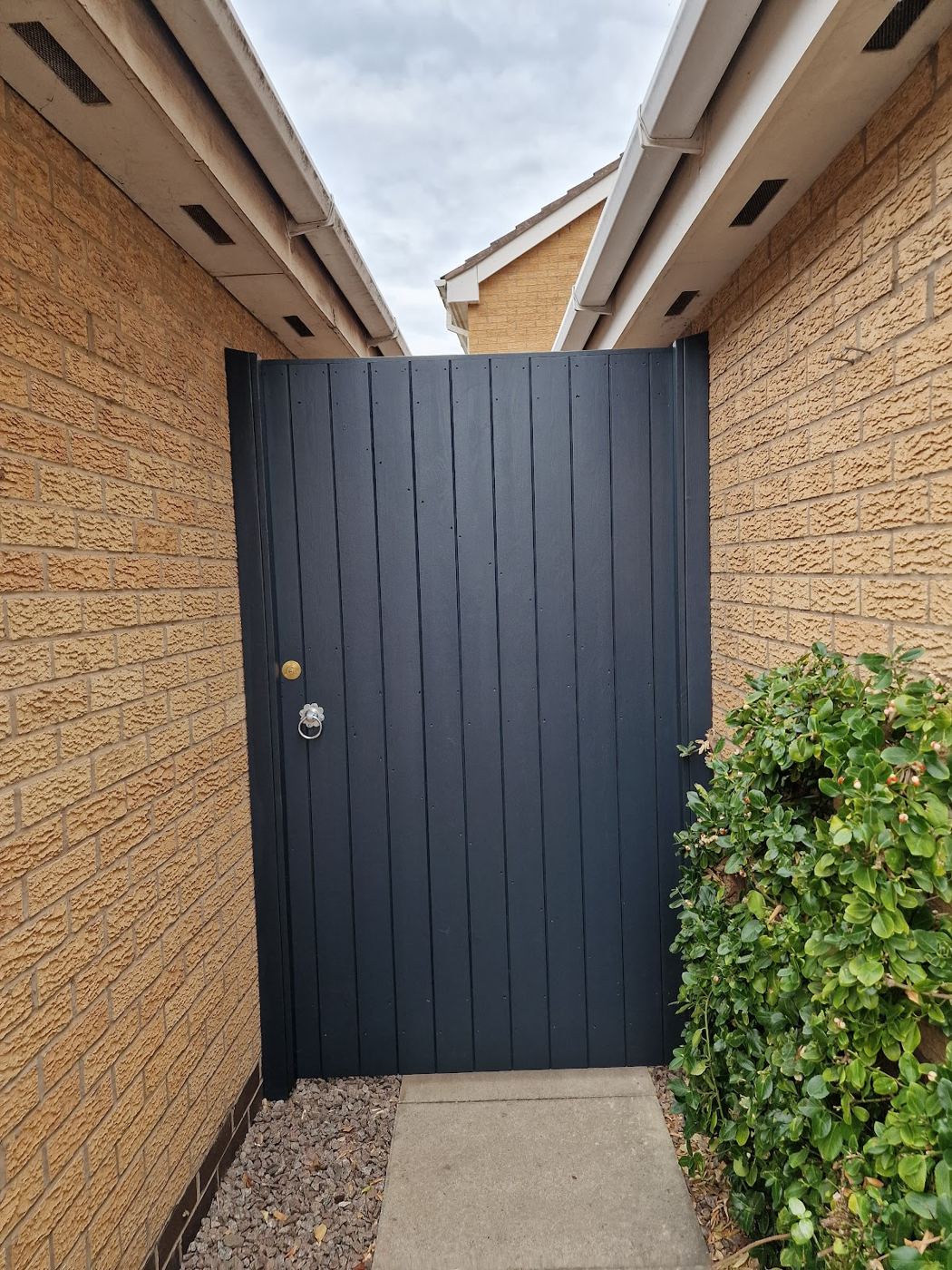 Anthracite painted side gate between brick walls