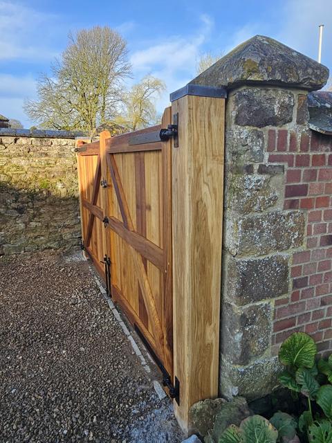 Oak side gate set into a stone garden wall